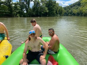 Three people looking at the camera while on a raft