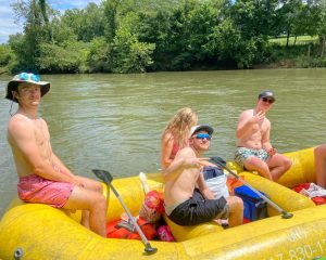 Three guys looking at the camera on a raft on a float trip